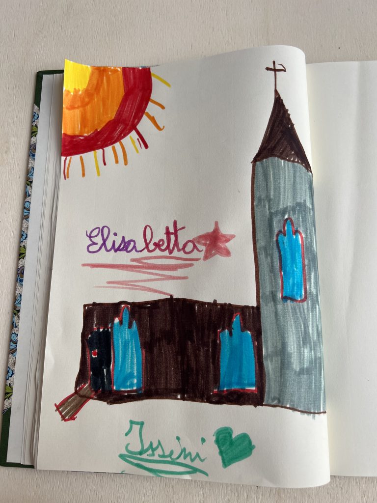 Disegno della facciata della Chiesa della Collegiata con l'ingresso preparato per le visite in sicurezza, fatto da una bambina sul libro delle dediche.