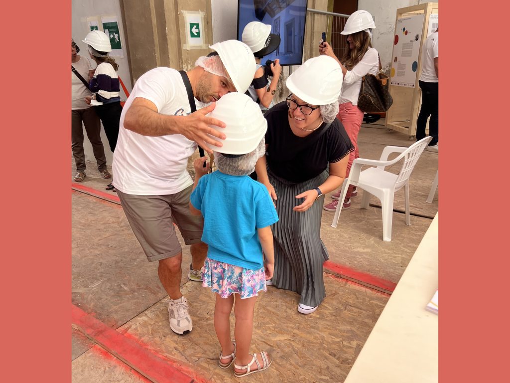 Distribuzione DPI - caschetti protettivi da cantiere all'Ingresso di Palazzo Saladini di Rovetino.